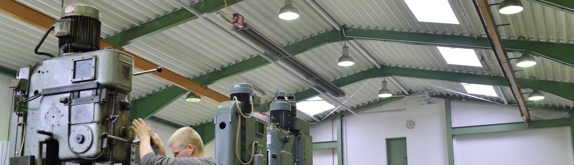 Ein langer Dunkelstrahler von Schwank hängt unter der Decke einer Industriehalle.